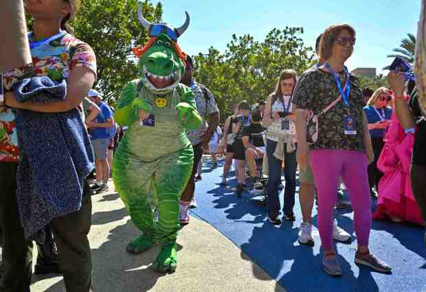 Sabrina Chicas is dressed as Partysaurus Rex, the T-rex from Toy Story as he appears in a Toy Story short film, while she waits to get into D23 in Anaheim, CA, on Friday, August 9, 2024. The Disney fan fest runs from August 9 to 11. (Photo by Jeff Gritchen, Orange County Register/SCNG)