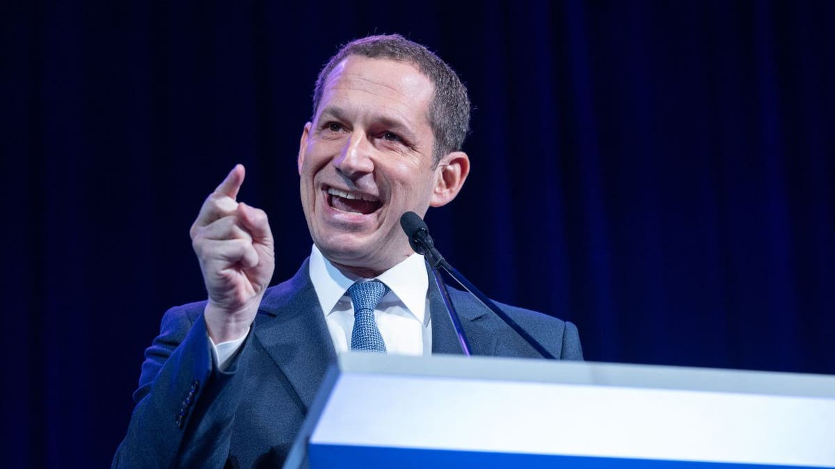 San Francisco Mayor Daniel Lurie speaking at a podium and gesturing with his hand