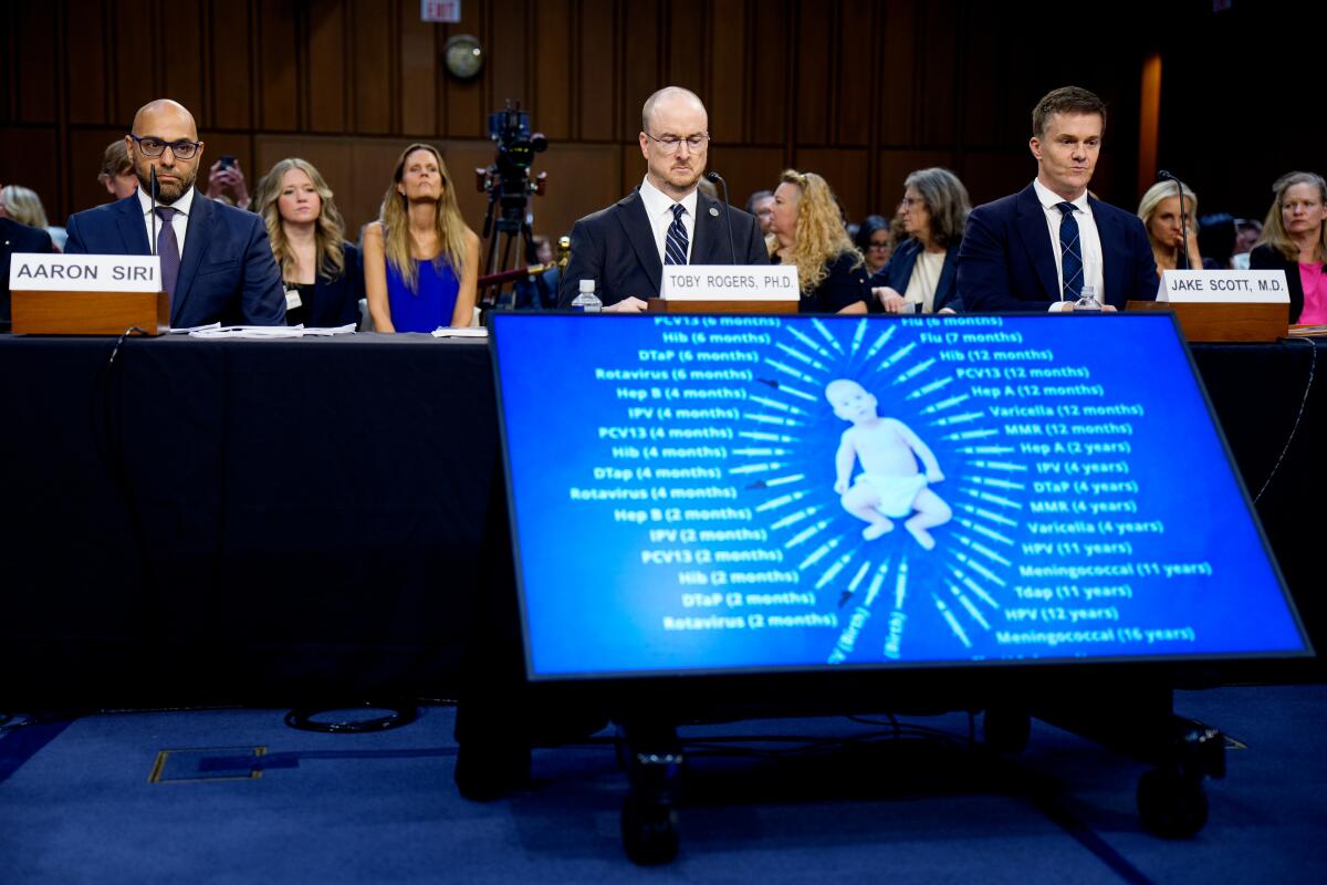 a child with a list of shots is depicted on a monitor during a short video as two men appear at a hearing