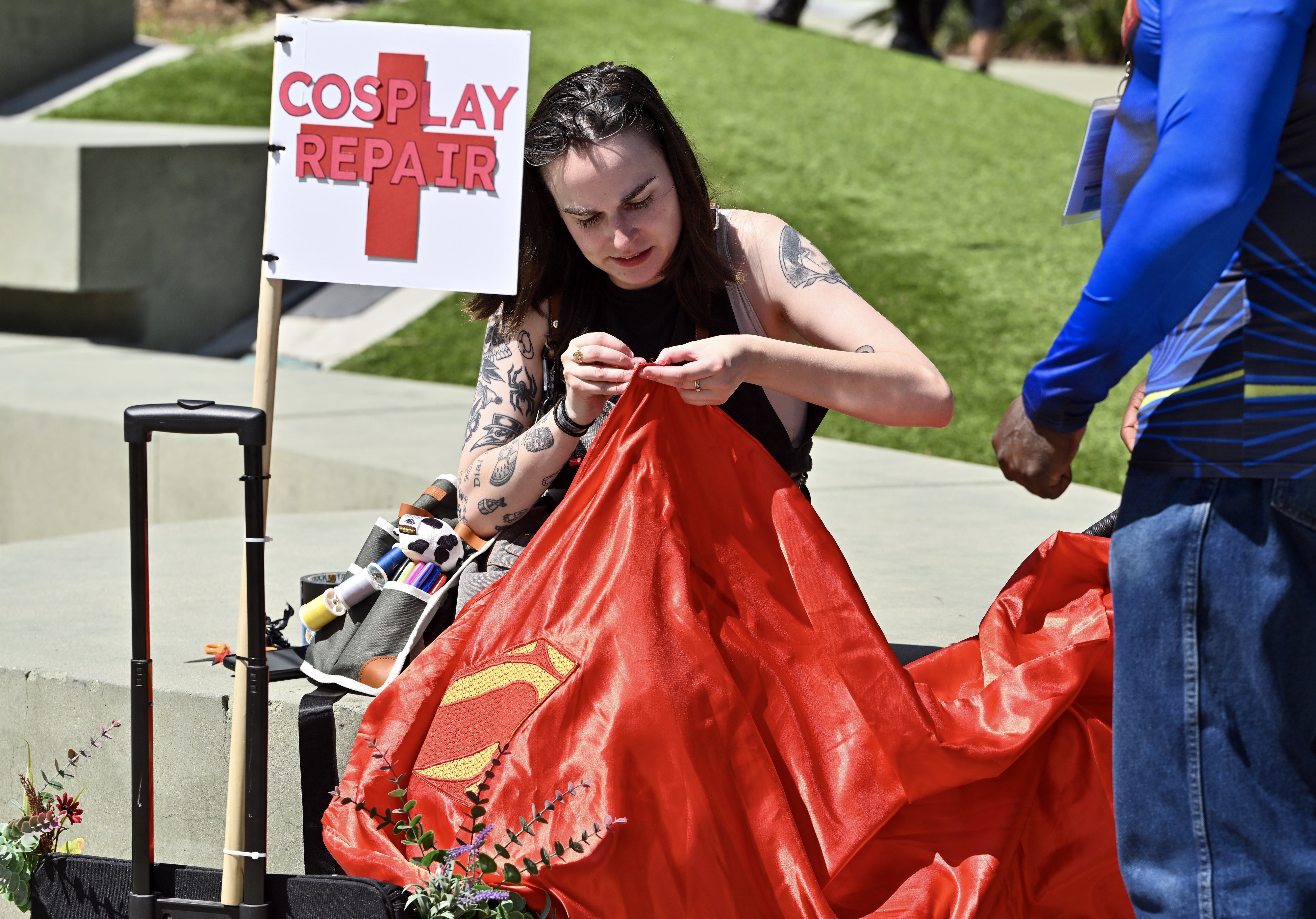 J Schremp helps mend Supermanâs cape during WonderCon at the...