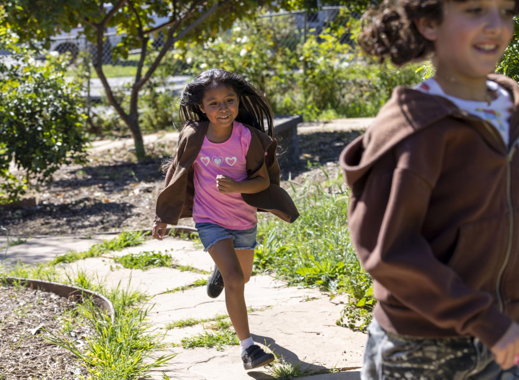 Quetzalli "Q" Domingo and Ramona Sunshine Herrera play tag at a Radical Monarchs troop meeting in El Sereno, Calif.