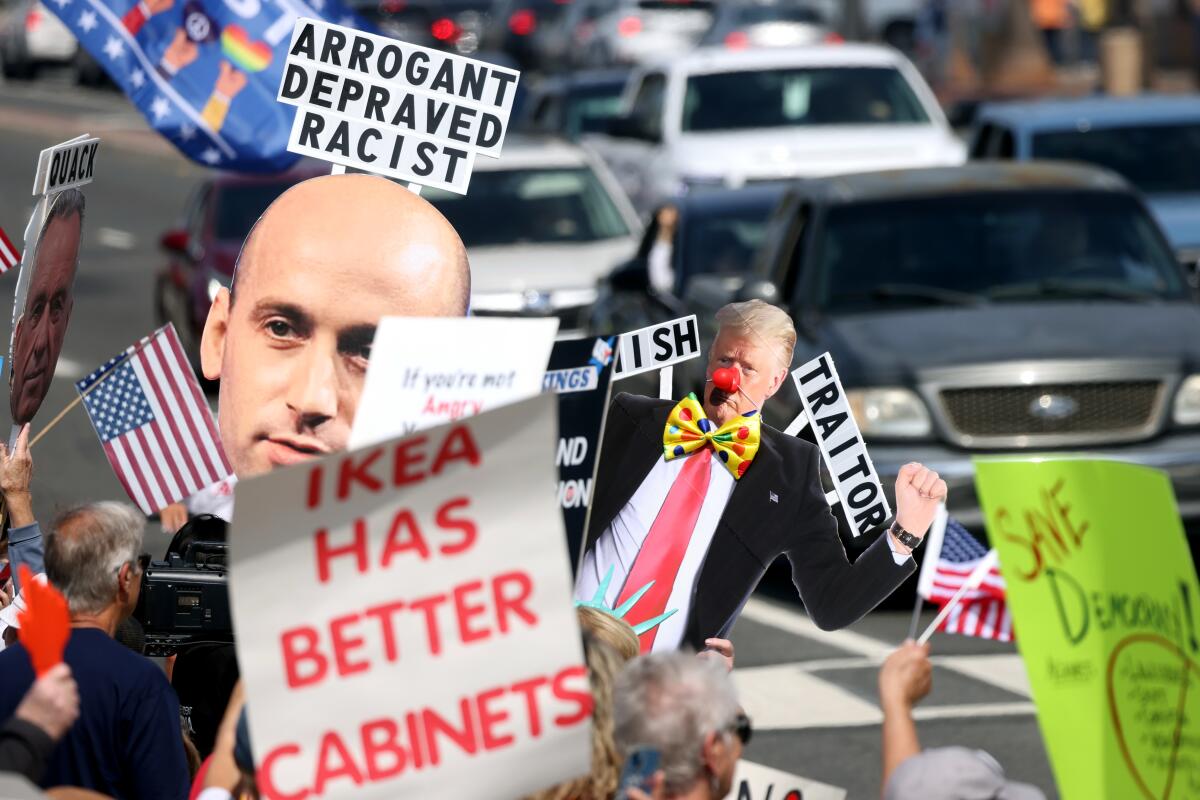 People holding signs at the "No Kings "rally in Huntington Beach