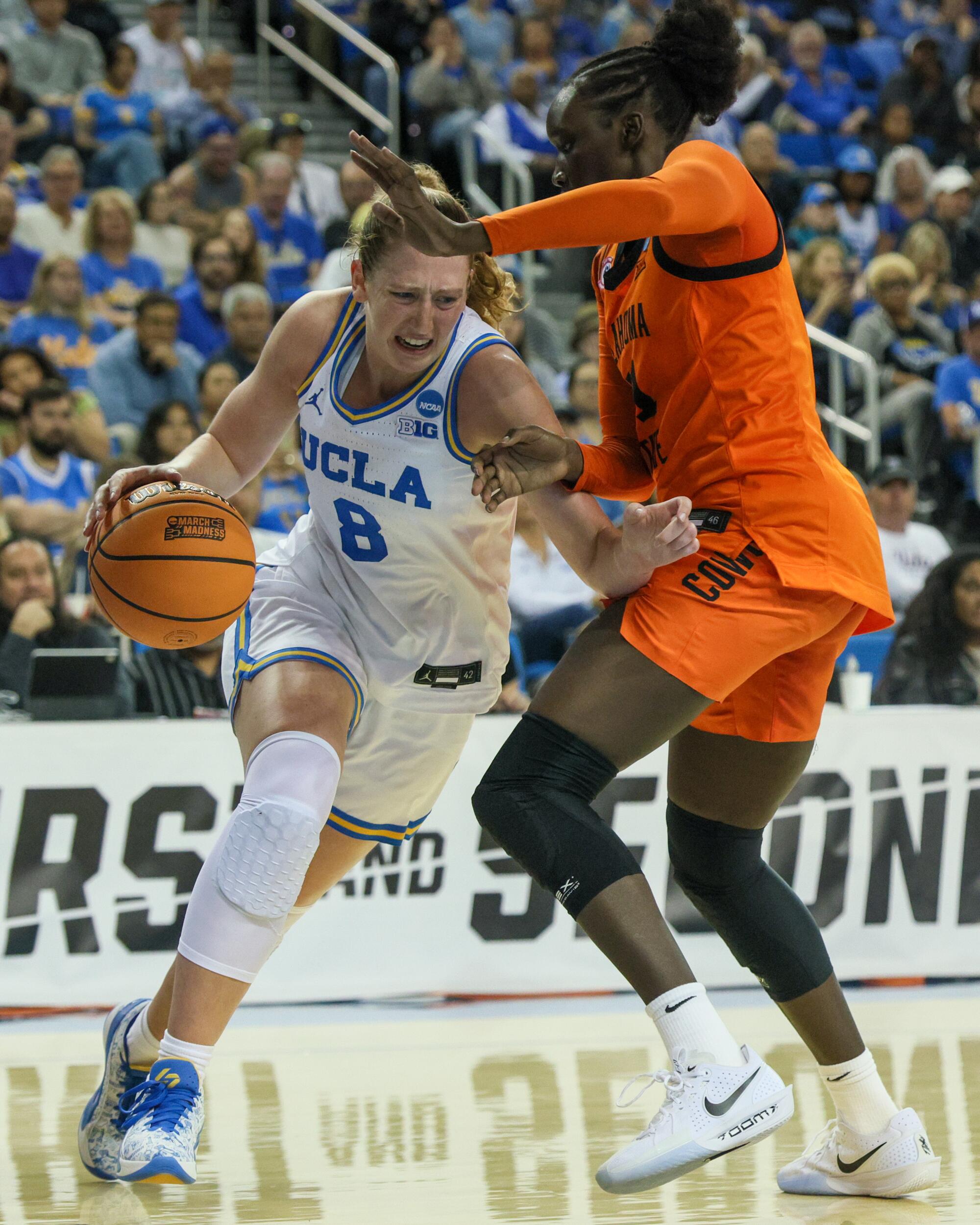 UCLA guard Gianna Kneepkens dribbles under pressure from Oklahoma State forward Achol Akot against the Oklahoma State.
