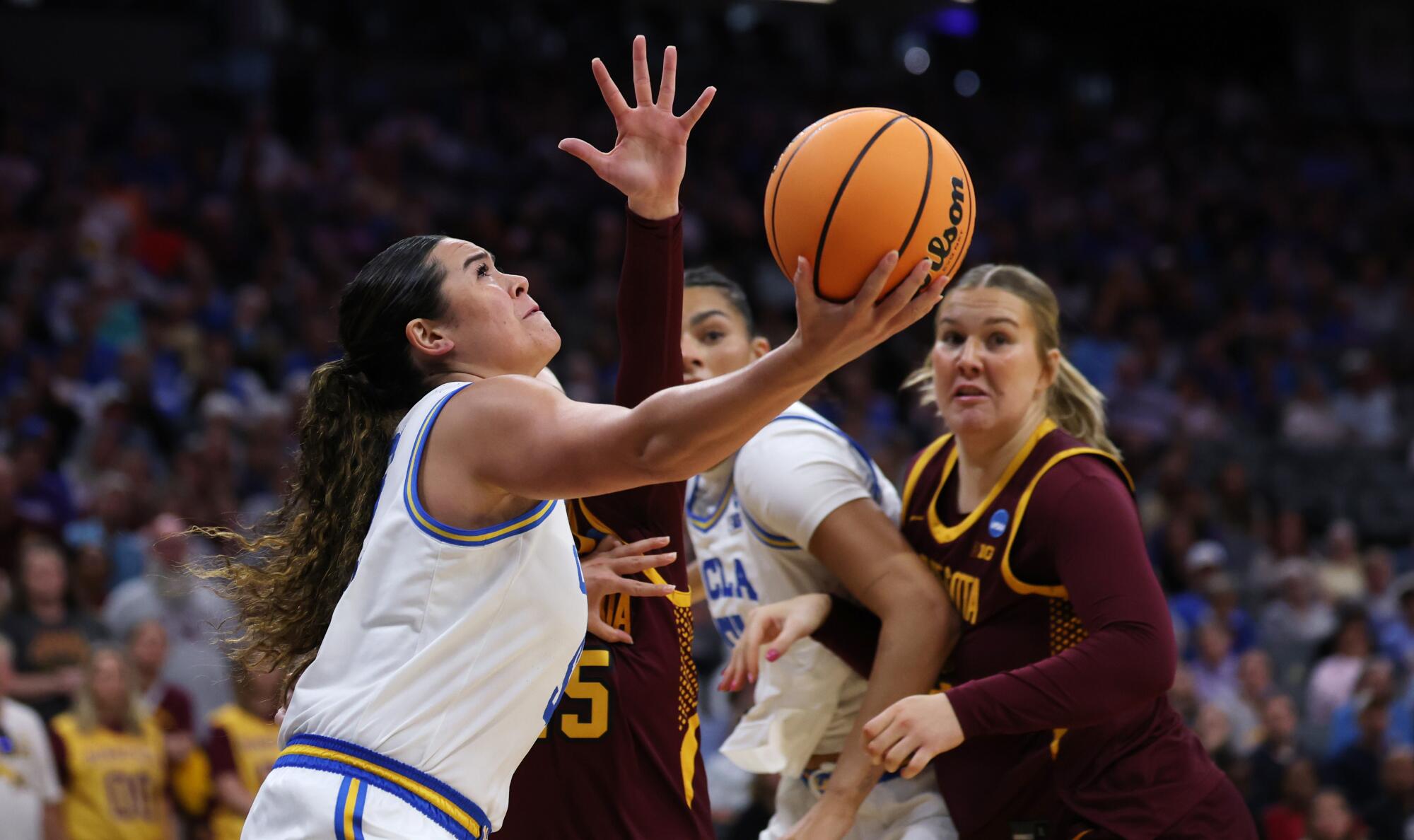 Charlisse Leger-Walker hits a reverse layup in front of Minnesota's Grace Grocholski during the tournament.
