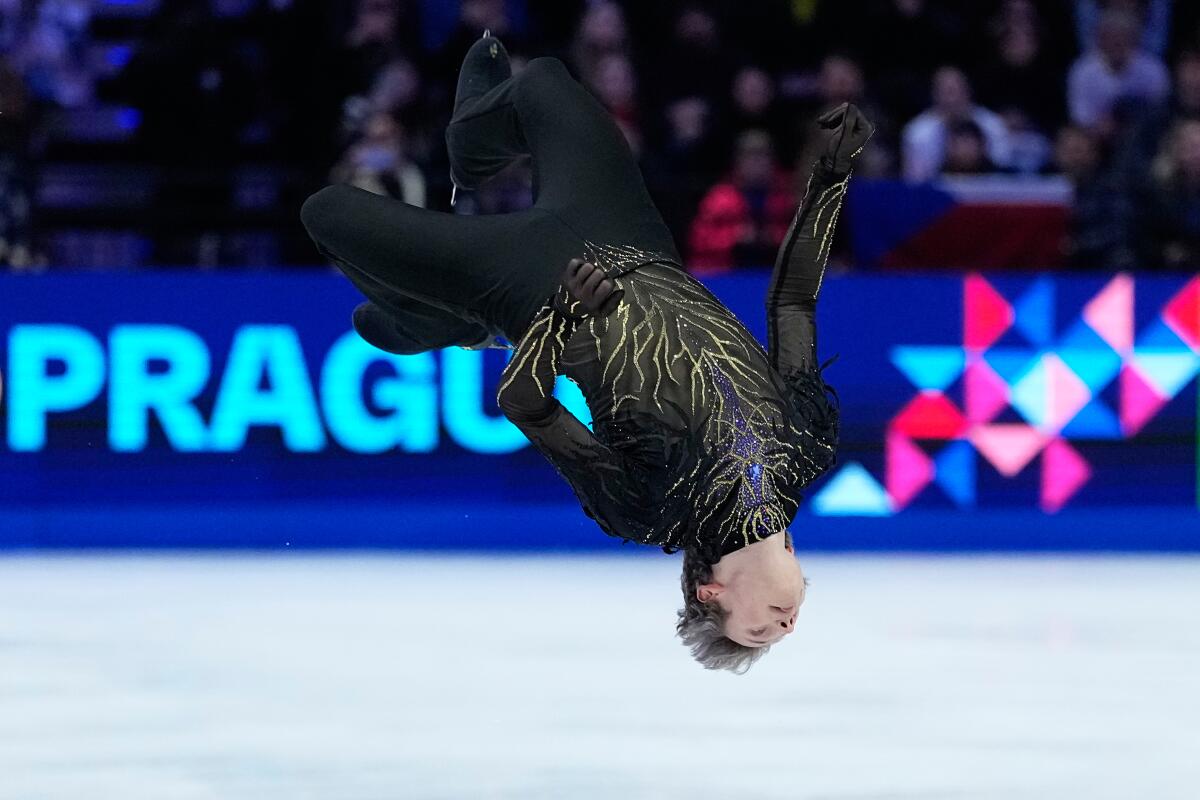 Ilia Malinin is upside down as he performs a backflip during his free skate on Saturday.