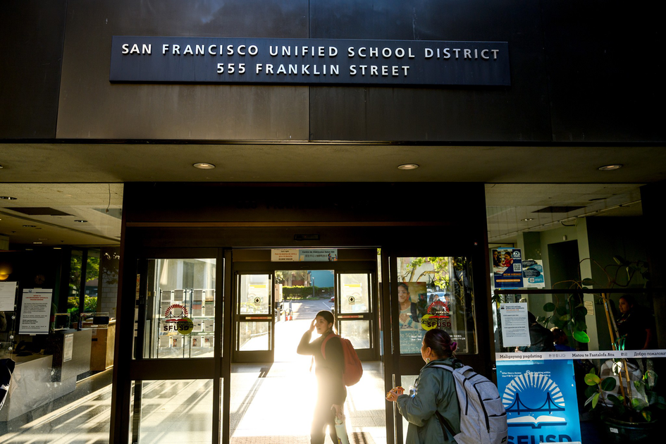 San Francisco Unified School District entrance at 555 Franklin Street with two people entering through glass doors.