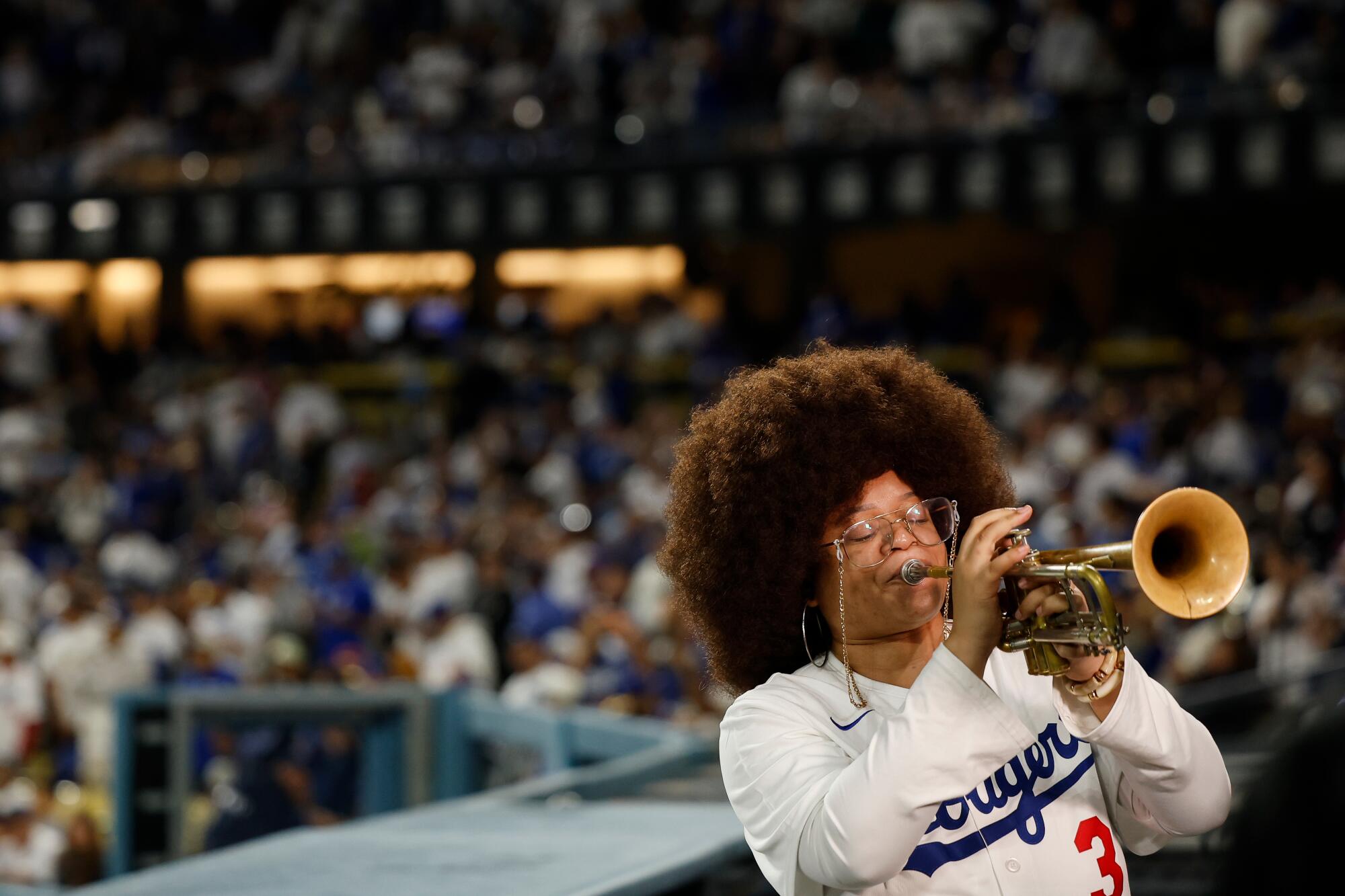 Tatiana Tate plays the trumpet as Dodgers closer Edwin Díaz takes the mound.