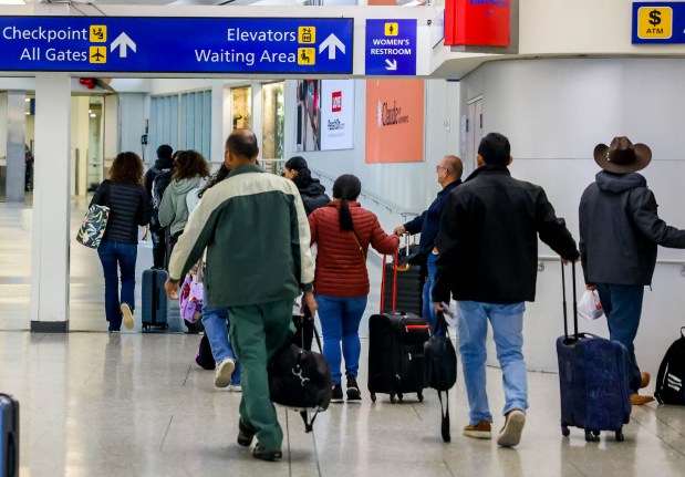 Travelers head to the checkpoint entrance at the Oakland International Airport in Oakland, Calif., on Friday, Dec.20, 2024. Thousands of holiday travelers begin the winter break this weekend. (Ray Chavez/Bay Area News Group)