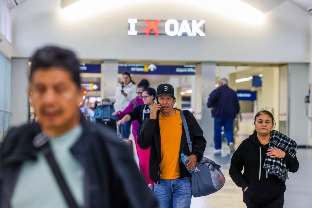 Travelers exit after arriving at Oakland International Airport in Oakland, Calif., on Friday, Nov. 7, 2025. (Ray Chavez/Bay Area News Group)