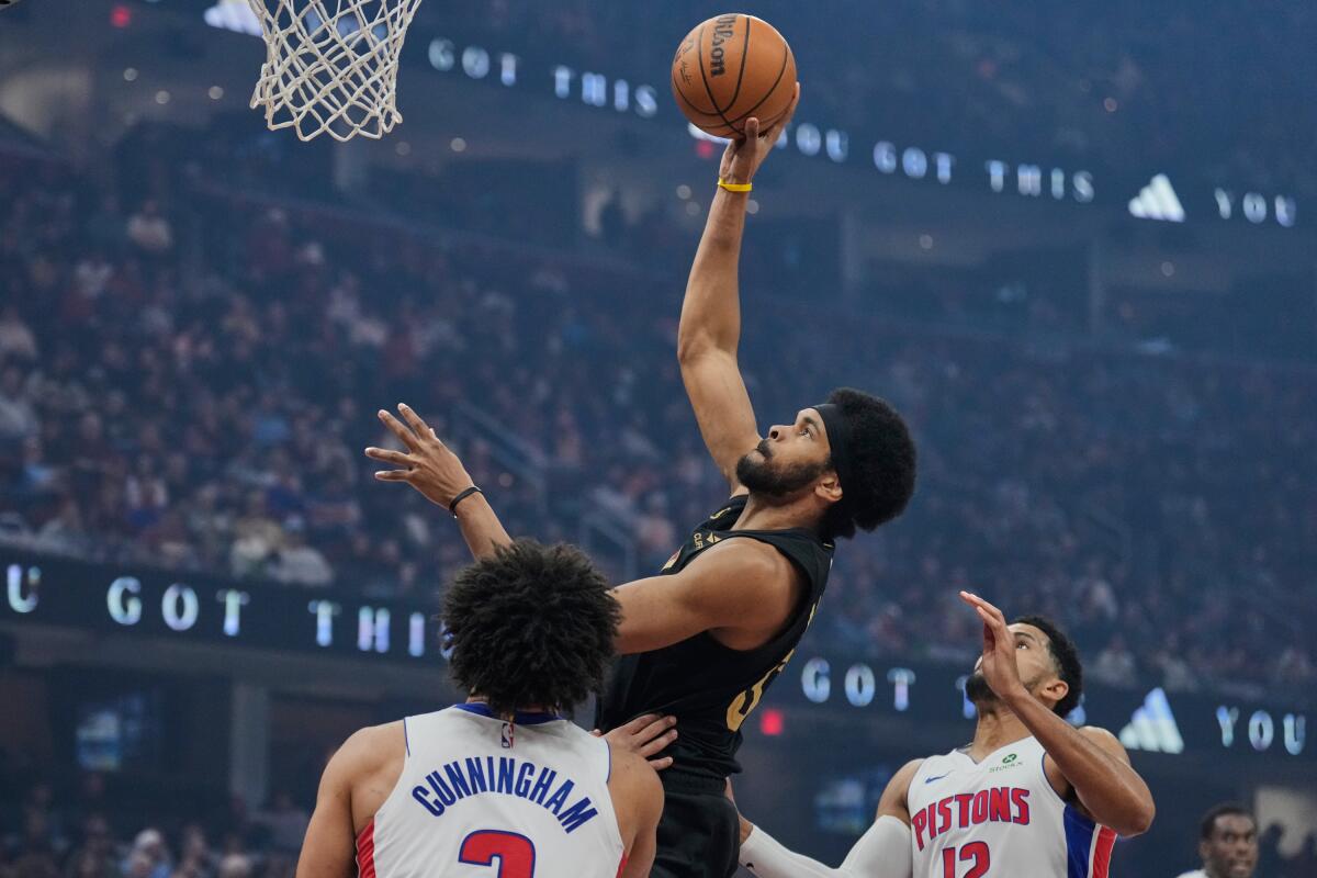 Cleveland's Jarrett Allen shoots between Detroit's Cade Cunningham, left, and forward Tobias Harris on March 3.