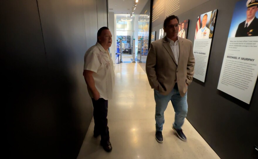Navy SEAL Museum San Diego Executive Director Brian "Beef" Drechsler (right) is shown with KPBS reporter John Carroll at the museum on March 23, 2026.
