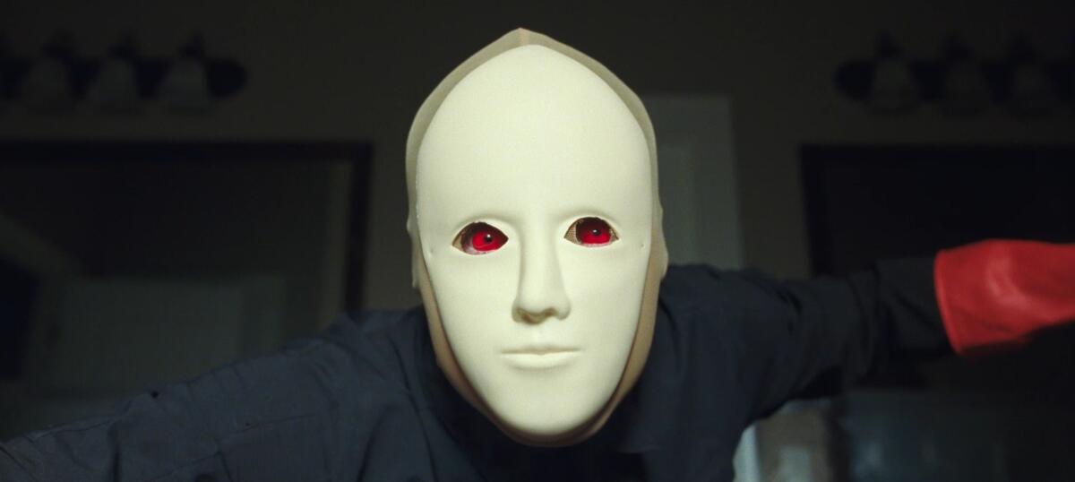 A man in a white man looms in front of the lens.