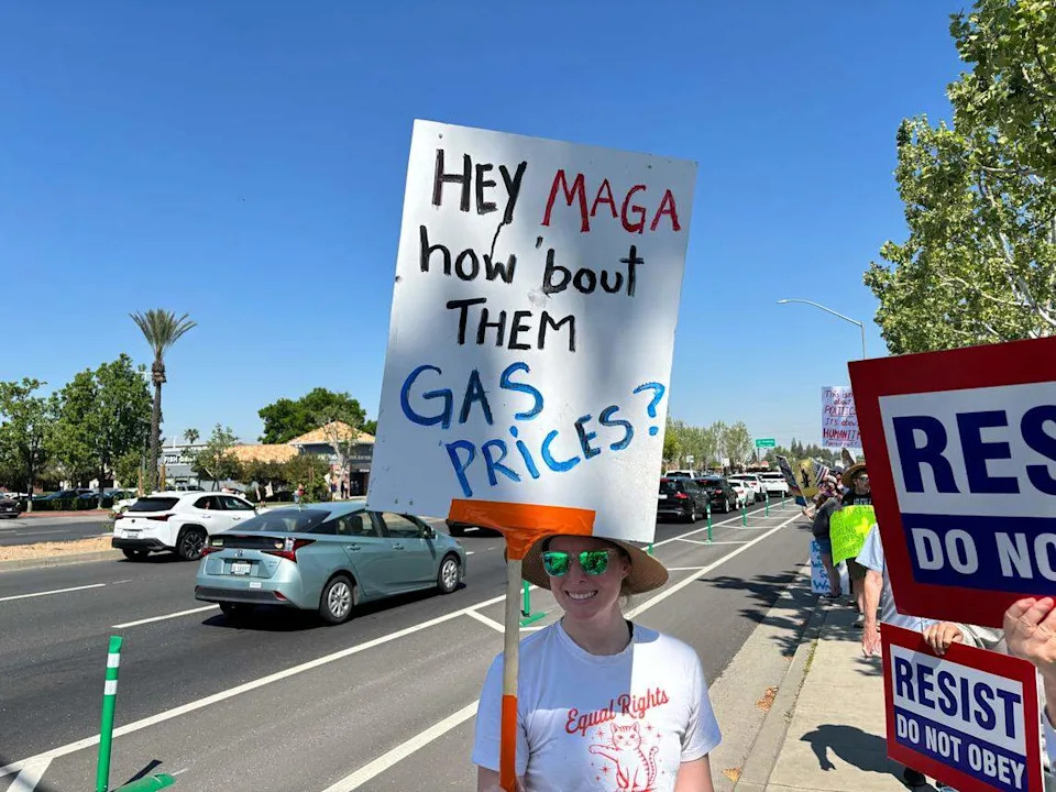 Protester holds sign about gas prices at Fresno’s “No Kings” protest near on Blackstone Avenue near River Park on Saturday March 28, 2026.