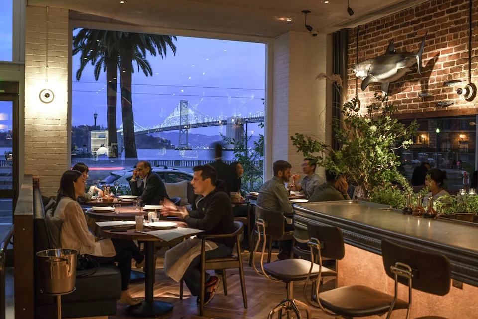 Customers dine at Angler, located along the Embarcadero in view of the Bay Bridge, in San Francisco. (Photo by Bonjwing Lee; courtesy of Angler)