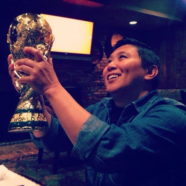 Karen Tongson holding up a fake World Cup in 2014.