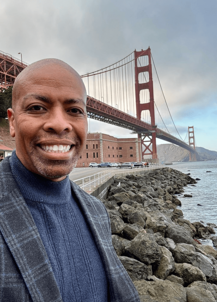 Paul Henderson smiling in front of the Golden Gate Bridge.