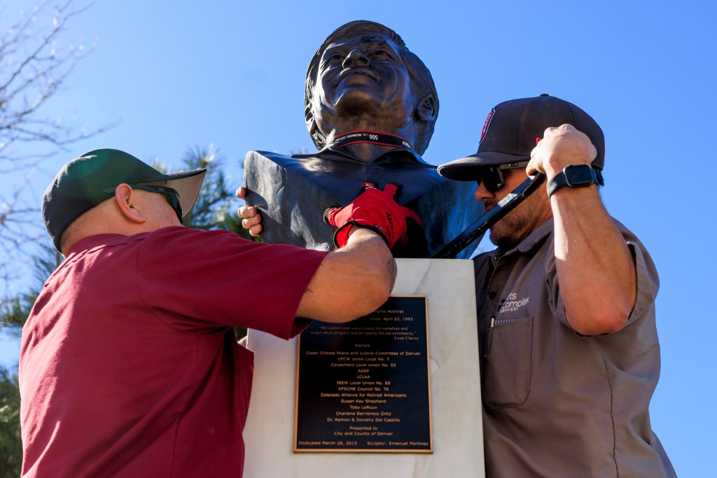 Workers remove a bust of Cesar Chavez from a park in Denver, Colorado.