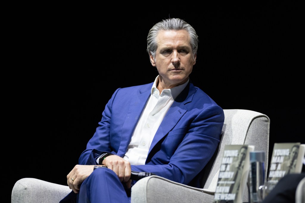 California Governor Gavin Newsom sits in a chair at an event promoting his book, "Young Man in a Hurry."
