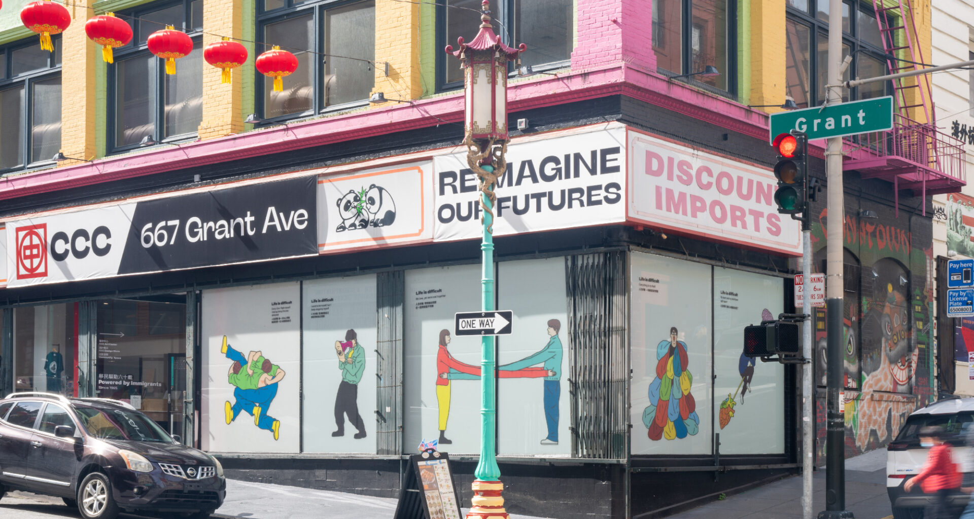 corner building with illustrations in windows, red lanterns hanging across street