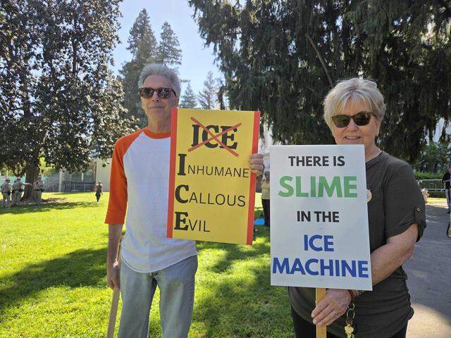 Eric Scherrer, left, and Kitty McVey show off their protest signs Saturday morning at the Capitol in Sacramento as part of the “No Kings” protest against the Trump administration.