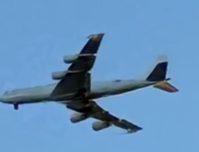 A Boeing E-6B Mercury "Doomsday Plane" flying through a blue sky.