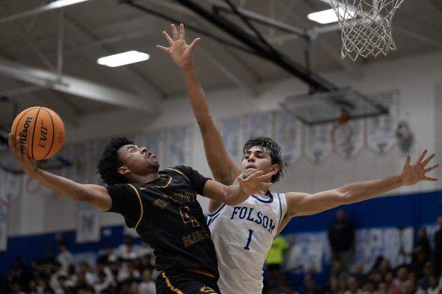 The Kings Academy Knights’ Xavier Barnett scores over the Folsom Bulldogs' Joven Dulay in the second half in the CIF Northern California Regional Division I boys basketball championship on Tuesday in Folsom.