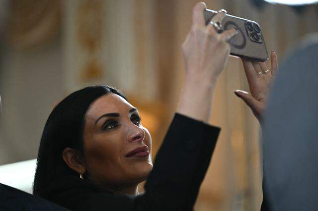 Political activist Laura Loomer films with her cellphone as US President Donald Trump takes part in a dedication ceremony for Southern Boulevard, in the ballroom at Mar-a-Lago in Palm Beach, Florida, on January 16, 2026. (Photo by ANDREW CABALLERO-REYNOLDS / AFP via Getty Images)