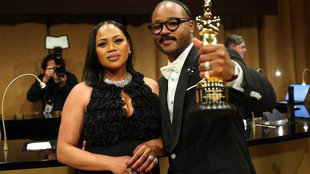US director Ryan Coogler (R) stands with his wife US film producer Zinzi Coogler holding his Oscar for Best Writing (Original Screenplay) for "Sinners" as they attend the 98th Annual Academy Awards Governors Ball at the Dolby Theatre in Hollywood, California on March 15, 2026. (Photo by ANGELA WEISS / AFP via Getty Images)