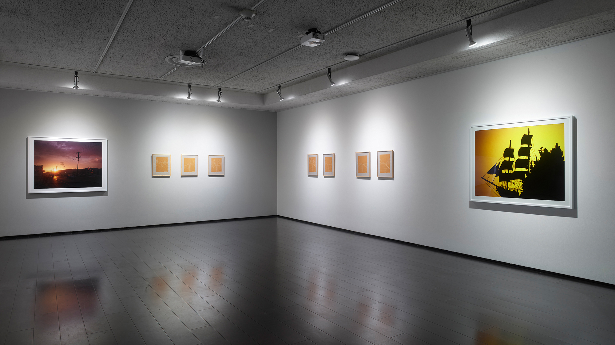 gallery view with colorful framed photographs and embroidered textiles