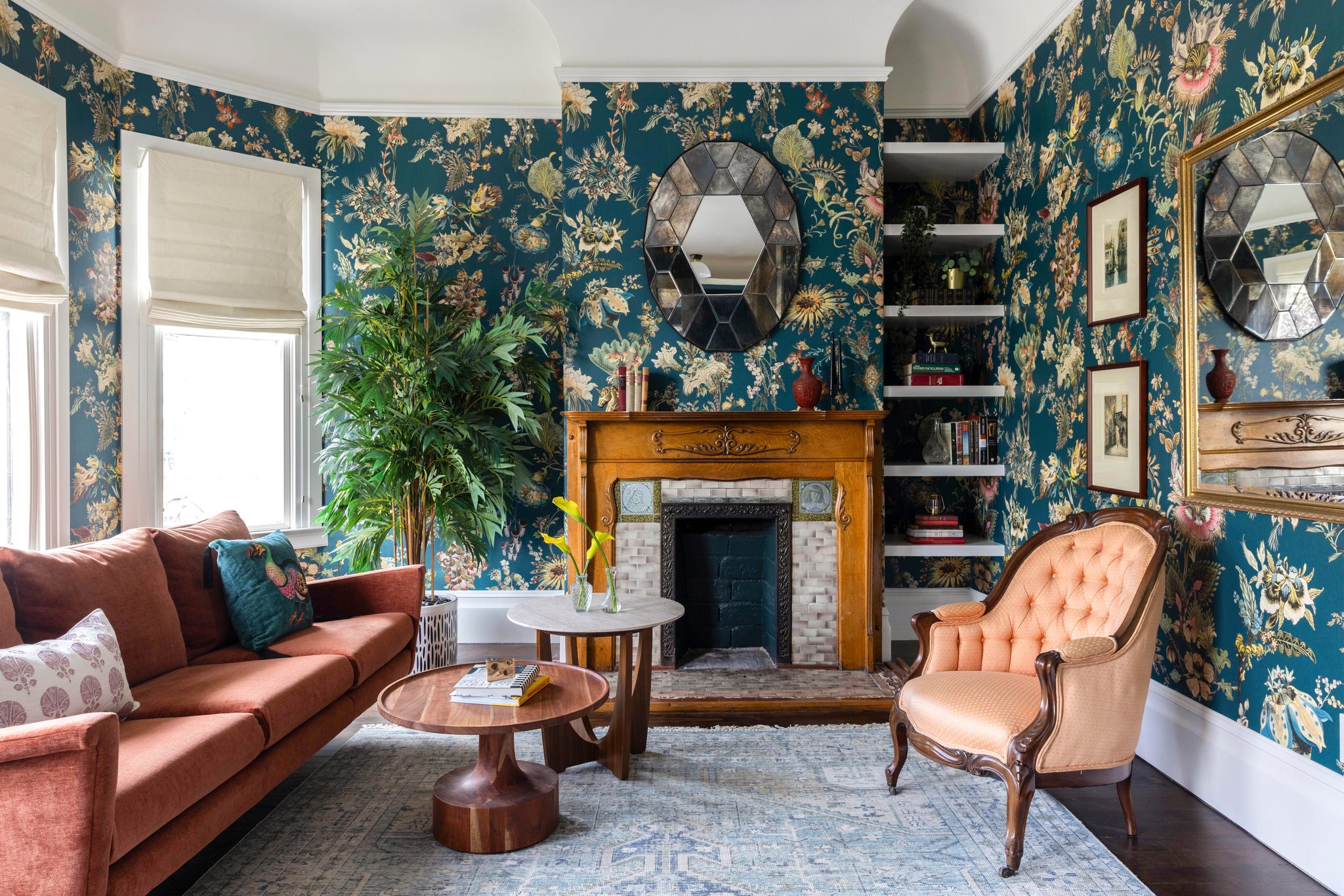 Living room with floral wallpaper, a fireplace, and vintage furniture