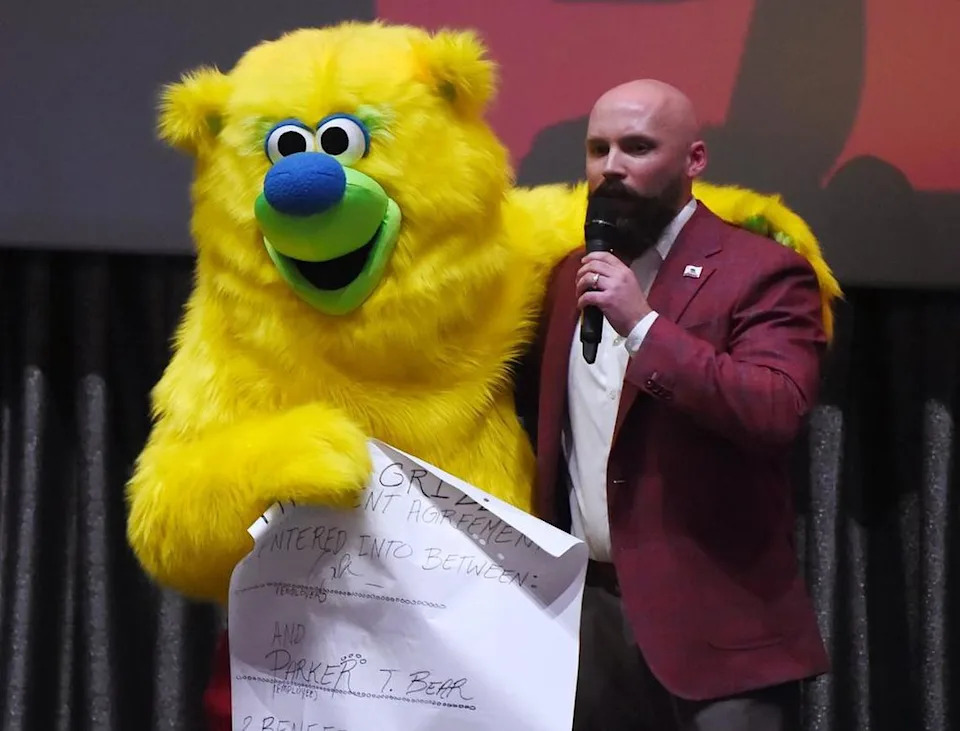 Fresno Grizzlies mascot Parker holds his new contract for the coming season with Fresno Grizzlies president Derek Franks during an unveiling event for the new team uniform colors Tuesday evening, Jan. 29, 2019 in Fresno.
