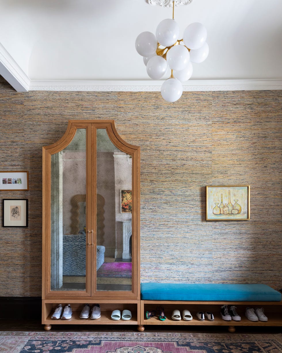 Wardrobe with mirrored doors and a shoe bench in a stylish interior.