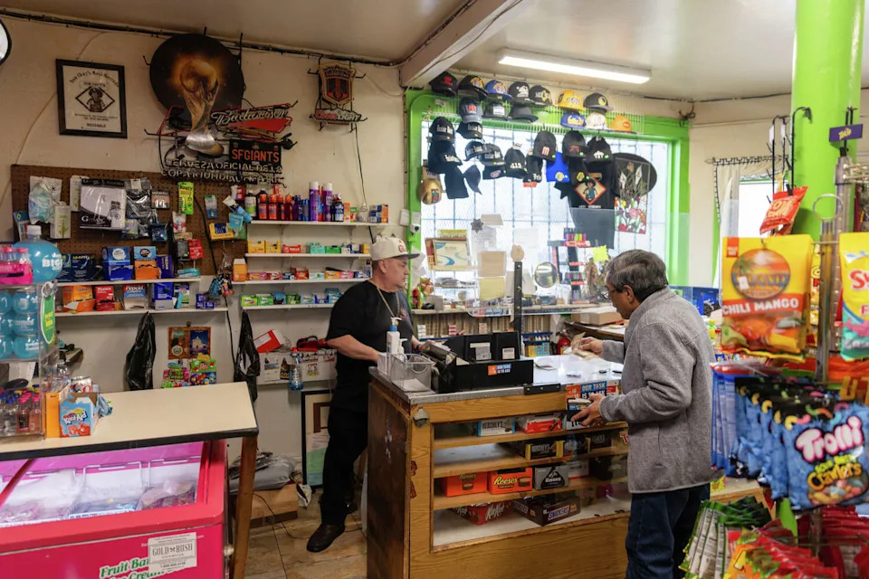 Gil Figueroa, the owner of Don Chuy's Mexi-Mercado in the Excelsior District of San Francisco, works behind the counter of the corner store on Feb. 25, 2026. (Douglas Zimmerman/SFGATE)