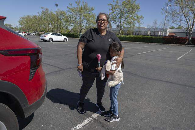 Erika Hernandez holds her daughter Natalia, 7, after they were separated as they participated in the Twin Rivers Unified School District strike rally at McClellan Park on Thursday. Hernandez said she was pushed by a guard as she tried to re-enter a hallway.