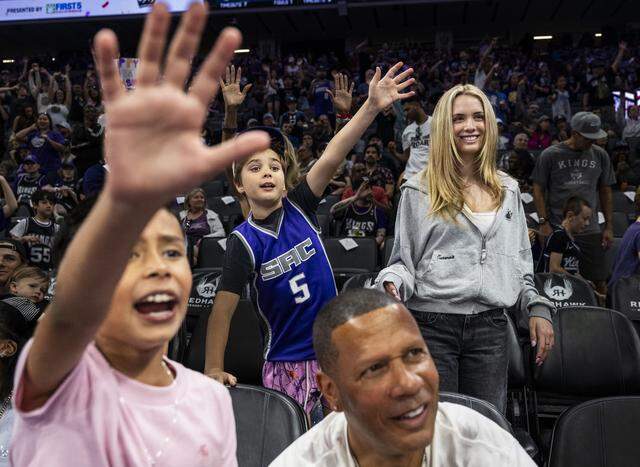 Dutch Newsom, Gov. Gavin Newsom’s youngest son, center, puts his hand up as he attempts to catch a ball at Golden 1 Center during a Sacramento Kings game on Sunday. His sister Montana stands with him at right. 