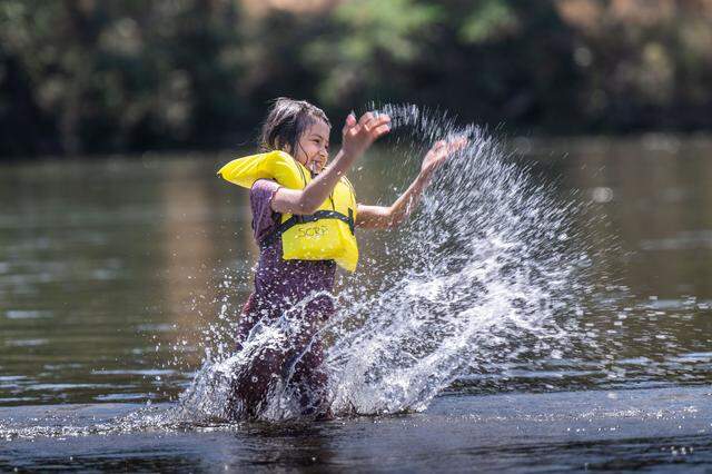 Tajala Jambdi, 7, of Sacramento splashes water while wearing a life jacket on the American River at River Bend Park in Carmichael on Thursday, June 27, 2024. The National Weather Service cautioned people to wear life jackets and be mindful of water temperatures in the Sacramento region’s waterways.