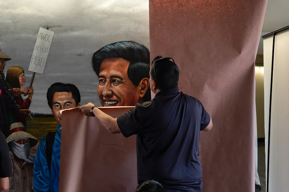 A worker covers a mural depicting Cesar Chavez at Santa Ana College in Santa Ana, Calif., on March 19.