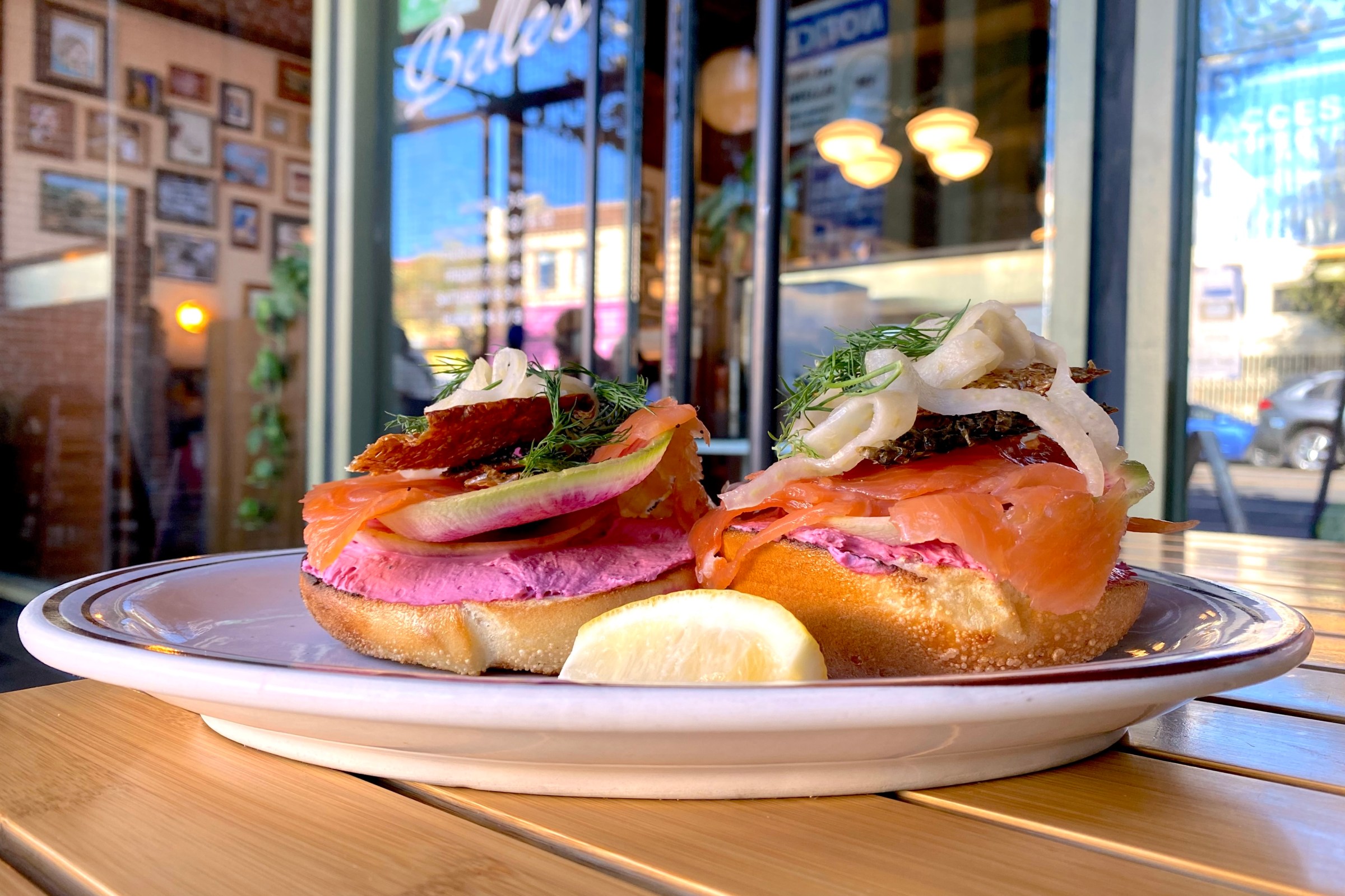 A bagel on a plate layered with nova lox, crispy salmon skin, radish, pickled fennel, dill & beet cream cheese at Belle’s Delicatessen & Bar in Highland Park.
