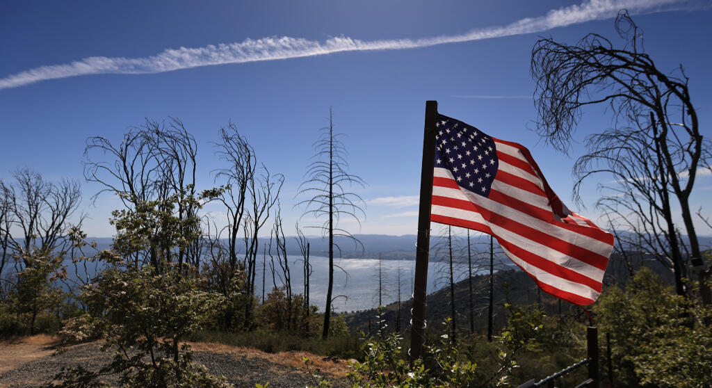 A flag floats in afternoon breezes above Clear Lake in...