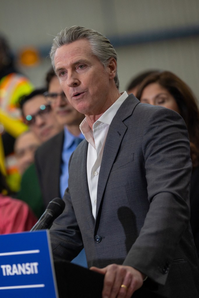 California Governor Gavin Newsom speaks at a podium to authorize an emergency loan for Bay Area transit agencies.
