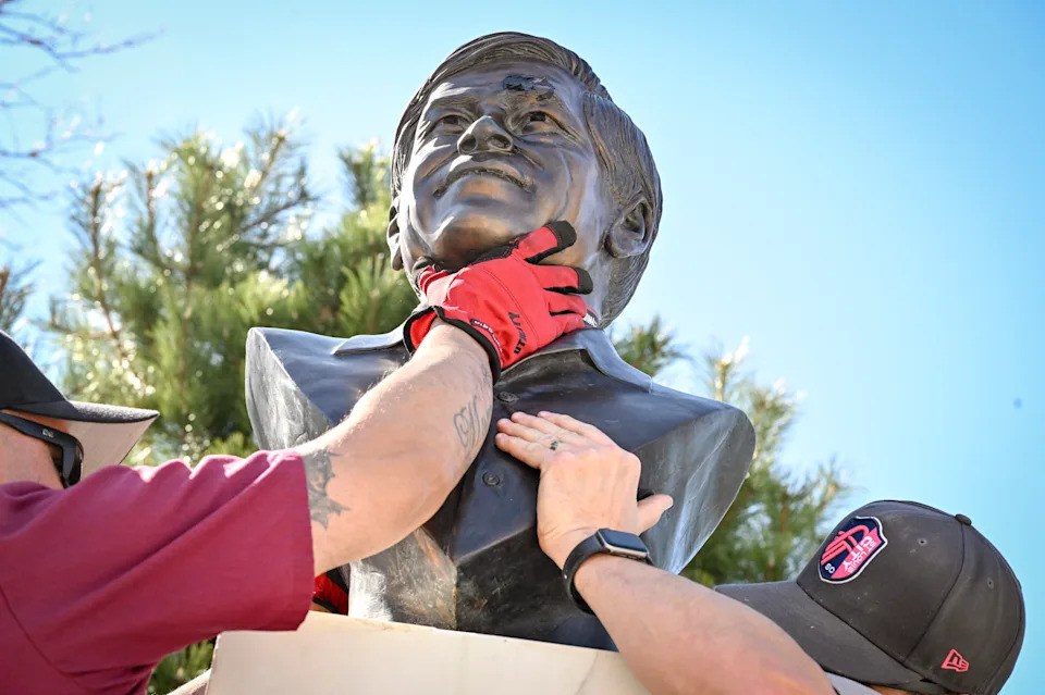 Workers remove the bust of Cesar Chavez at a park bearing his name in Denver on March 19.