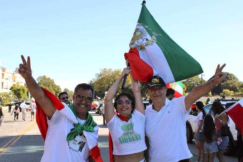 Several attendees waved Iranian Lion and Sun flags or wore them draped over their shoulders during the celebration. (Photo by Charlotte Calmès)