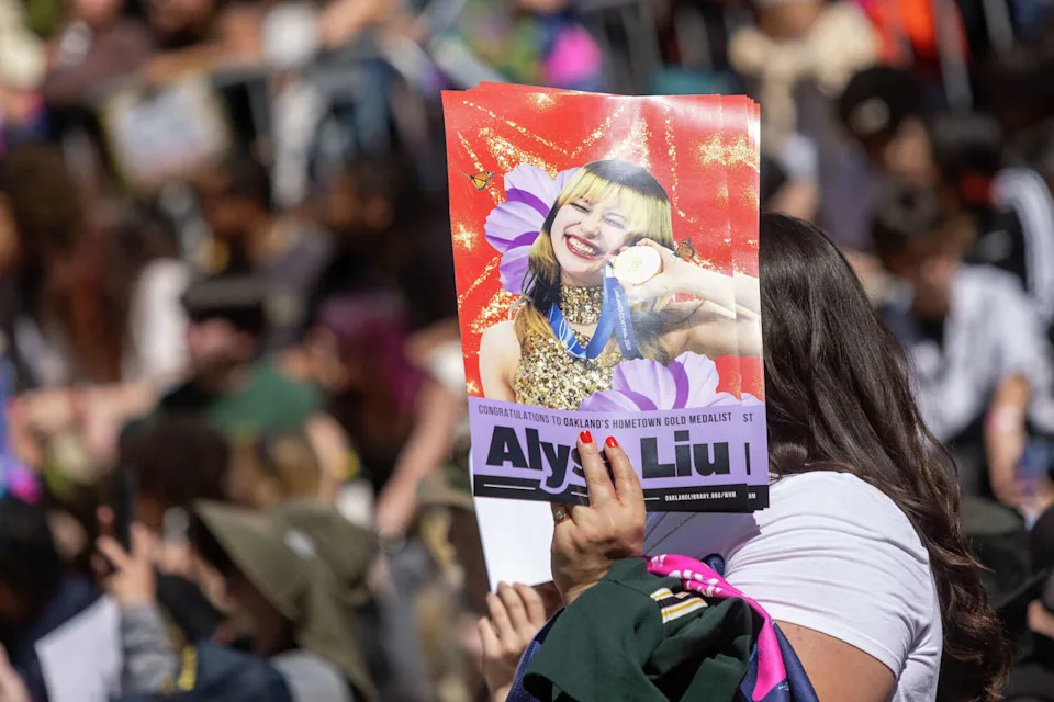 An attendee holds a poster during the Alysa Liu Celebration Rally at Frank Ogawa Plaza in front of Oakland City Hall in Oakland, Calif., on March 12, 2026. (Douglas Zimmerman/SFGATE)