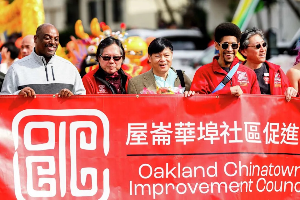 Arthur Liu, center, father of Olympic medalist Alysa Liu, marches in Saturday's Oakland Chinatown Lunar New Year Parade. (Noah Berger/For the S.F. Chronicle)