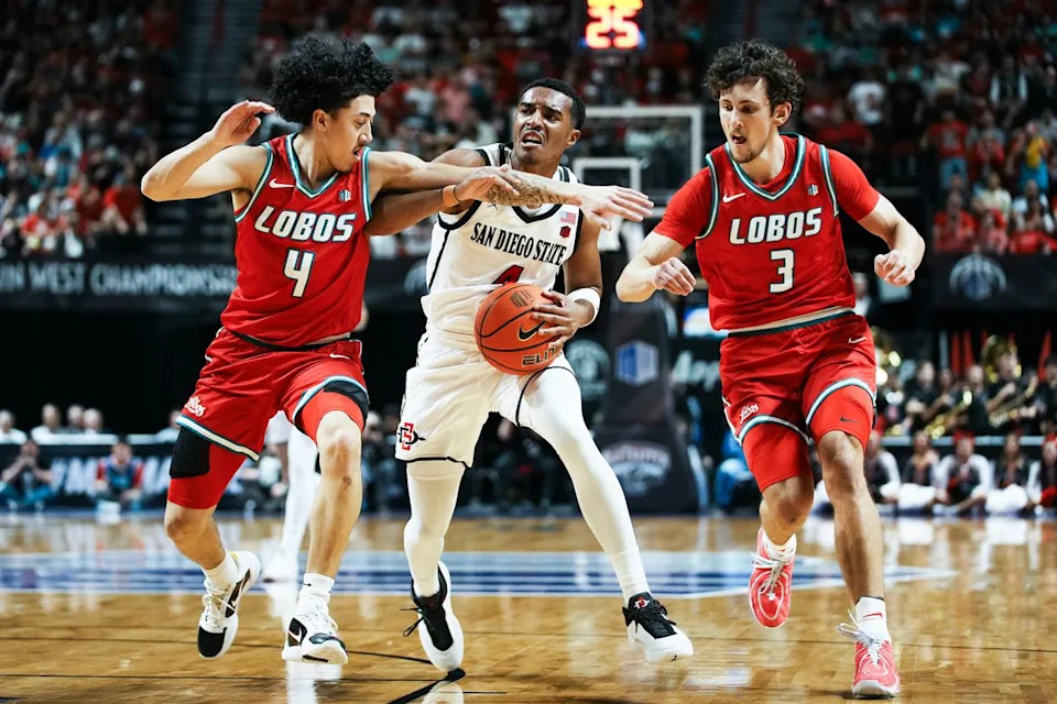 San Diego State guard Sean Newman Jr. (4) attempts to take the ball through New Mexico guard Uriah Tenette (4) and Luke Haupt (3) during the semifinal of Mountain West Championship tournament game between San Diego State and New Mexico on Friday March 13, 2026 in Las Vegas, Nev.