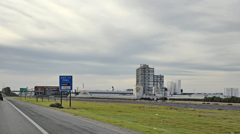 Highway signs in Earlimart, with a California Milk building in the background