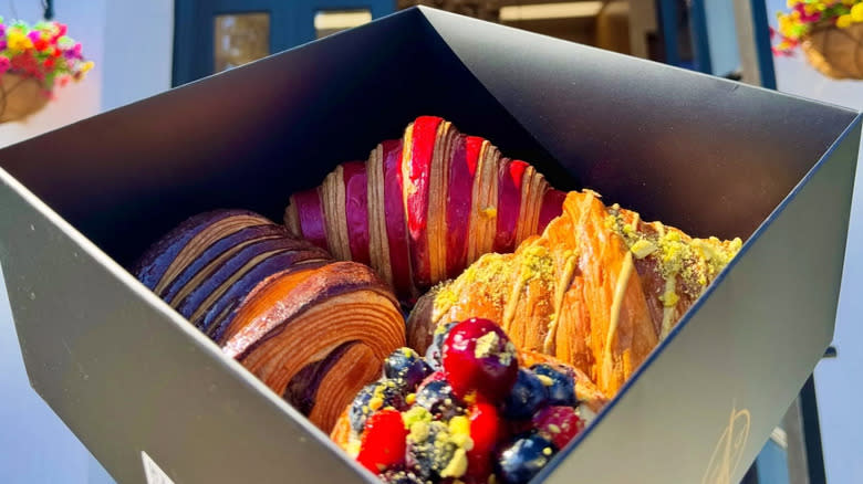 box of colorful pastries from Little France Bakery in front of exterior door