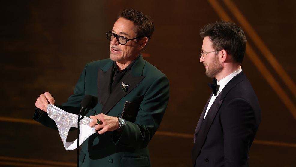 HOLLYWOOD, CALIFORNIA - MARCH 15: (L-R) Robert Downey Jr. and Chris Evans speak onstage during the 98th Oscars at Dolby Theatre on March 15, 2026 in Hollywood, California. (Photo by Kevin Winter/Getty Images)