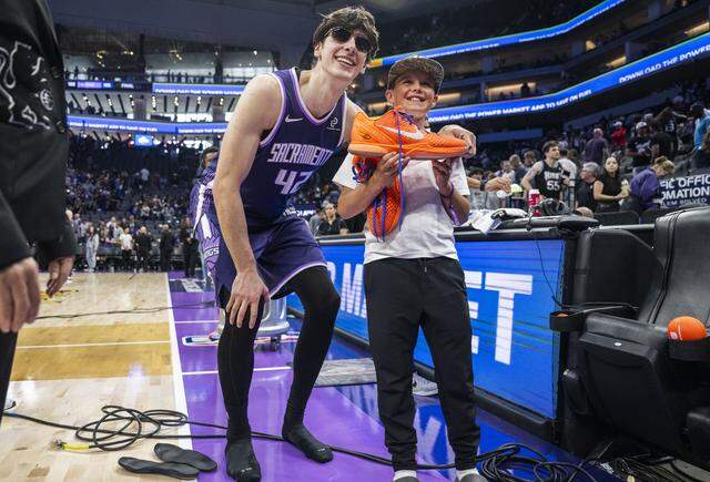 Sacramento Kings center Maxime Raynaud (42) stands for a photo with Henry McCarley, of El Dorado Hills, after giving him a pair of his game shoes at Golden 1 Center on Sunday.