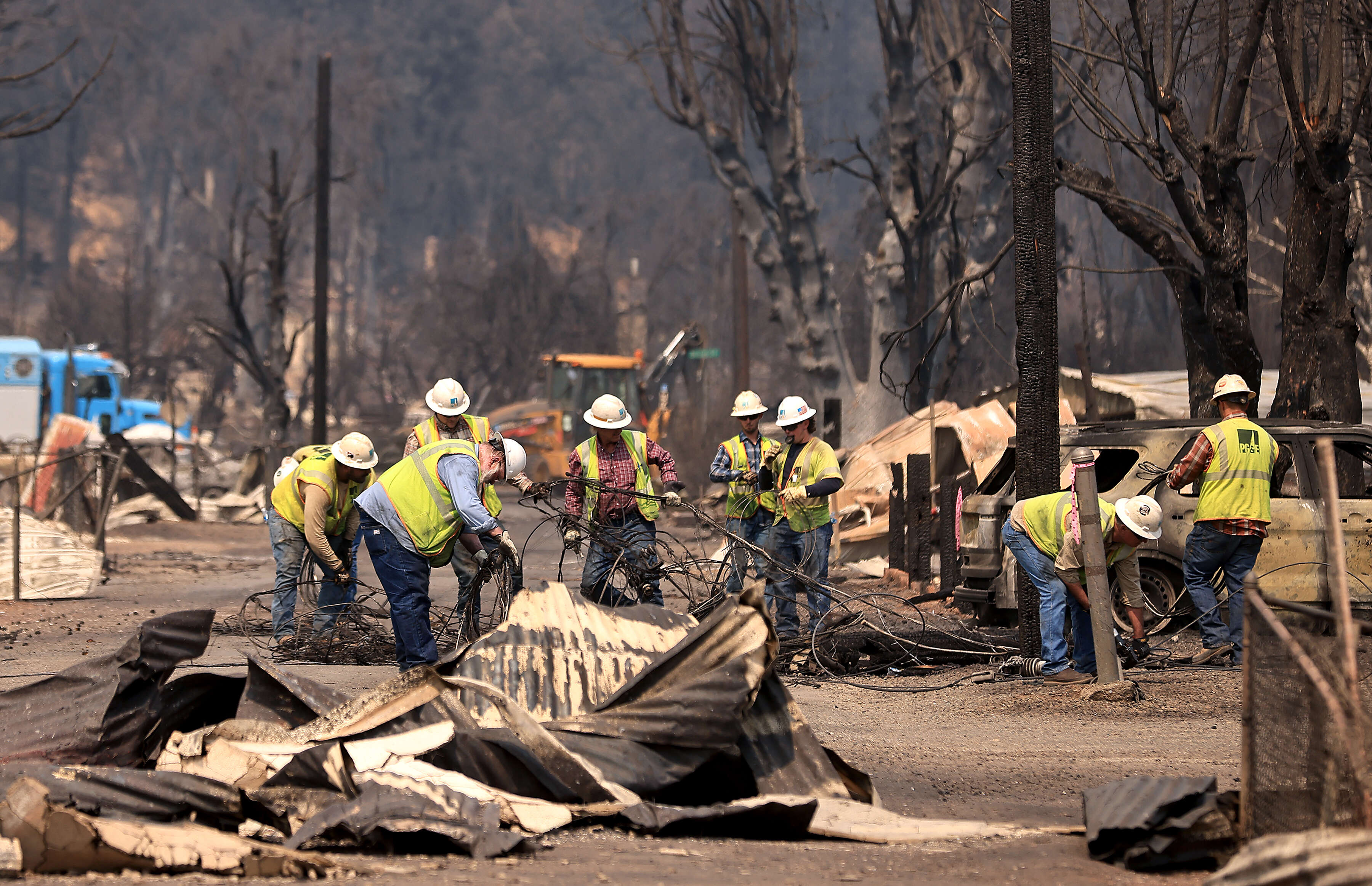PG&E workers begin the tedious cleanup of their utility equipment...